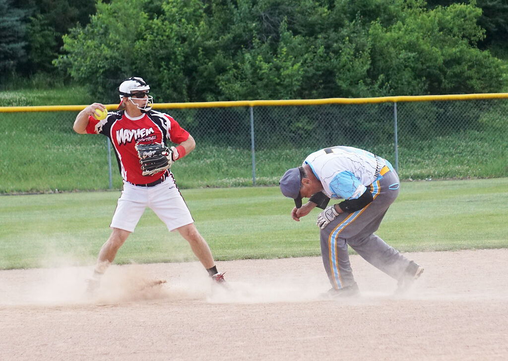 Bob Sandlin winds up to throw the ball while Terry Barnes ducks